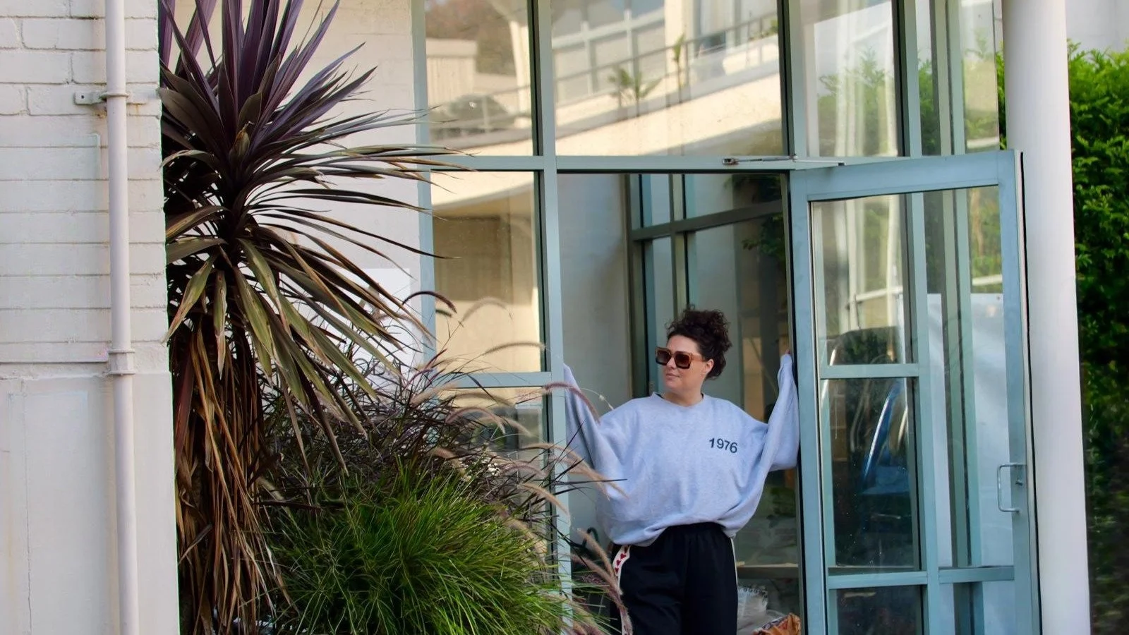 Flow Republic founder greeting students at the studio entrance, capturing the welcoming community, thoughtful design and premium yoga experience that defines the Flow Republic approach.