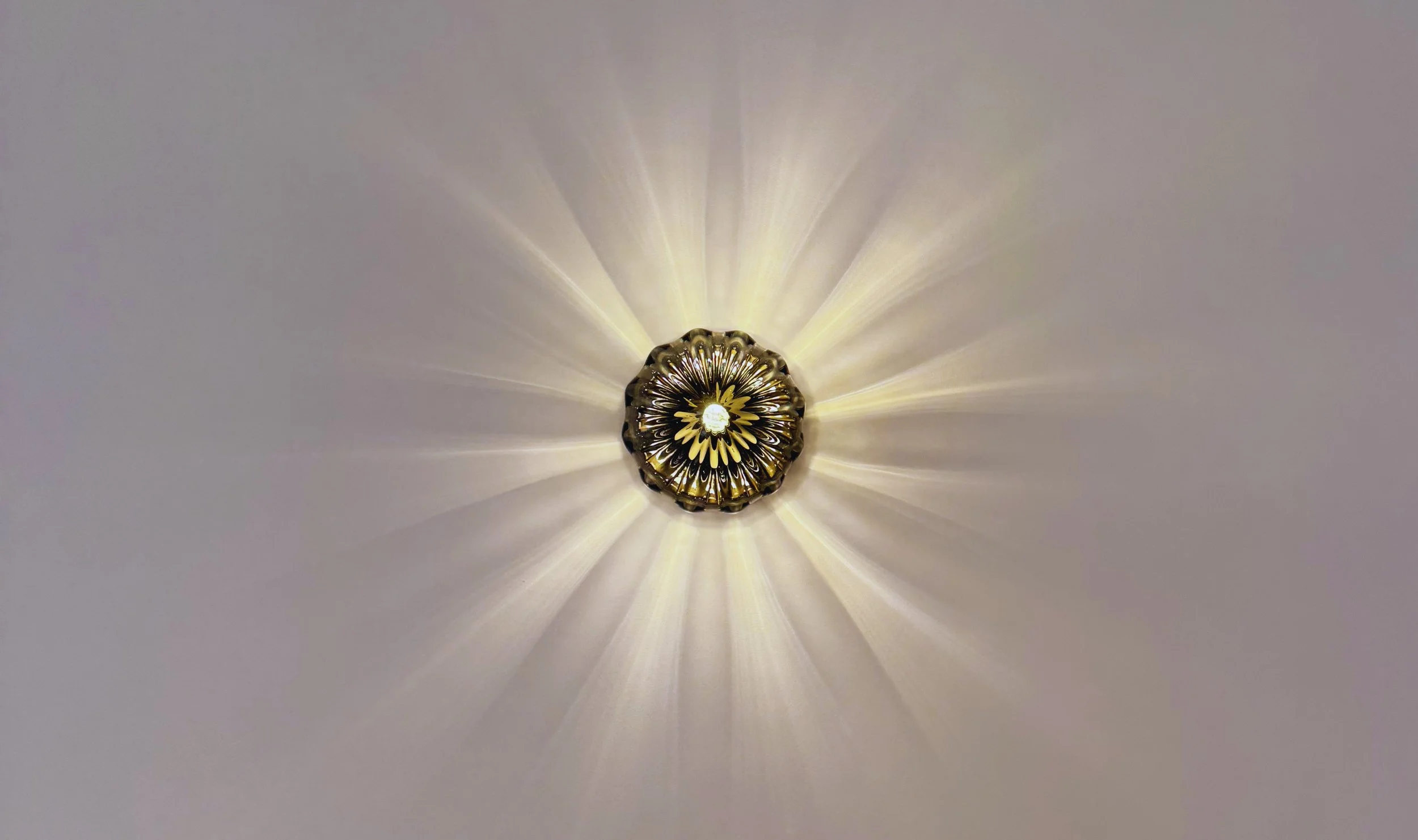 Decorative ceiling light casting a warm radial glow, creating a calm and welcoming atmosphere inside Flow Republic.
