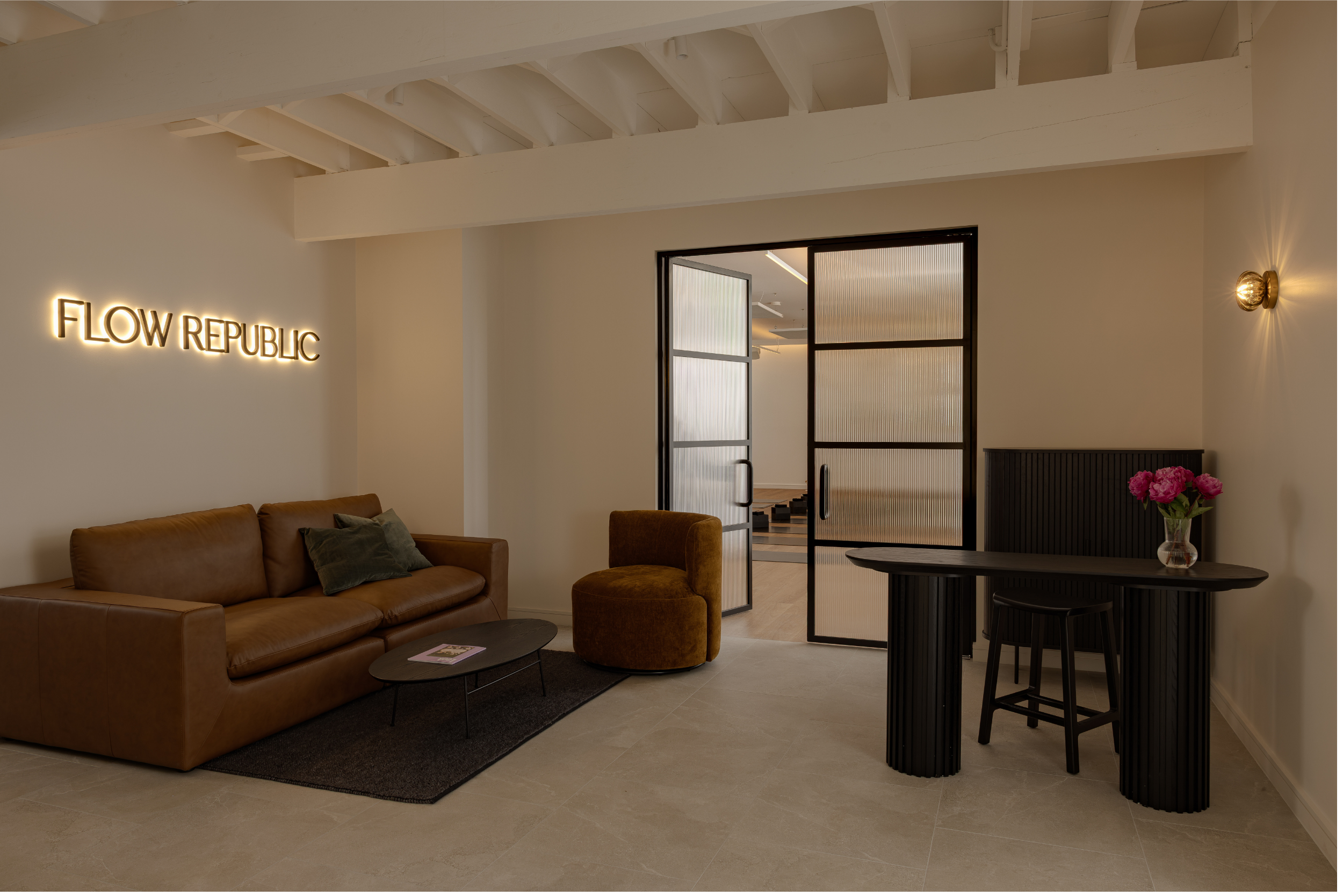 Reception area of Flow Republic, a premium yoga studio in Rozelle, Sydney, featuring a welcoming lounge, modern interiors and entrance to the yoga practice space.