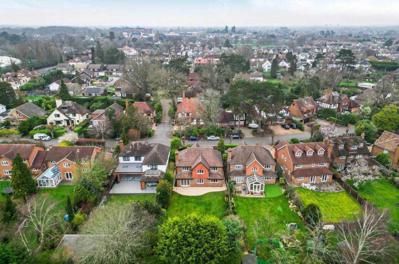 Aerial view of a suburban neighborhood with various houses and greenery.