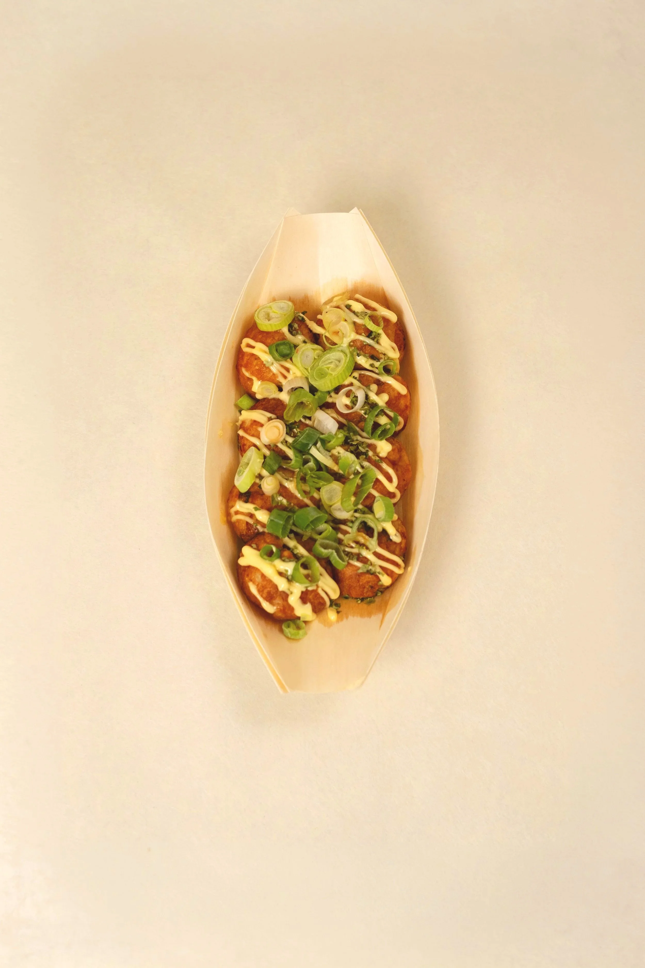 Takeout container with fried chicken topped with sliced green onions and drizzled with mayonnaise-based sauce. Spring onion.