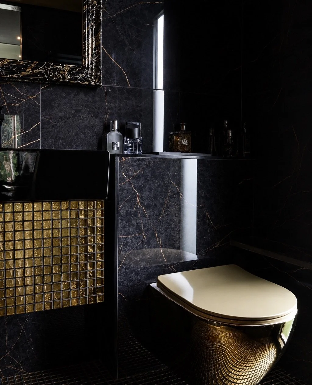 Compact bathroom inside NOCTURNE with dark marble walls, a wall-mounted toilet, bespoke cabinetry and integrated lighting.