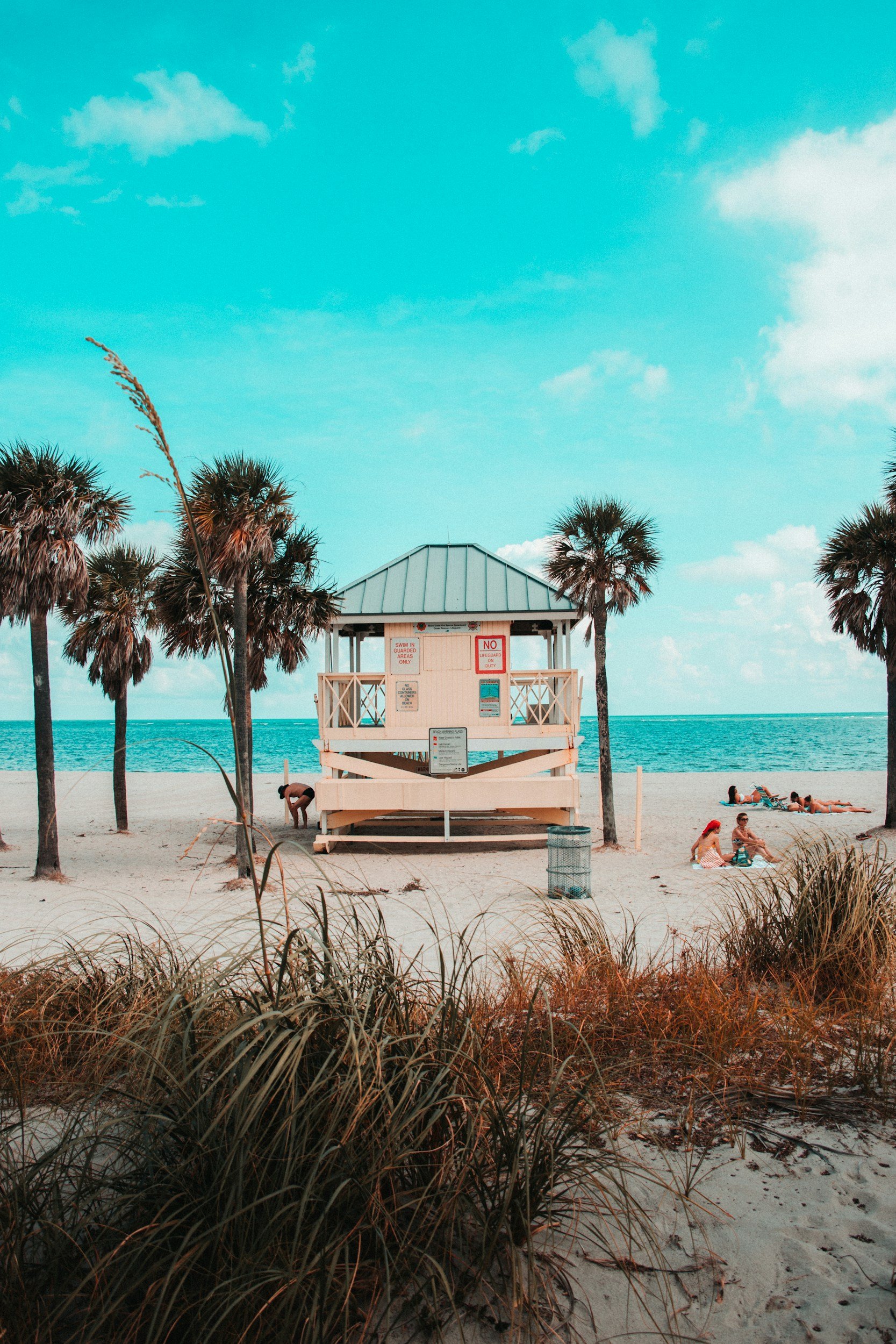 Gulf Coast image with people laying out on the beach.
