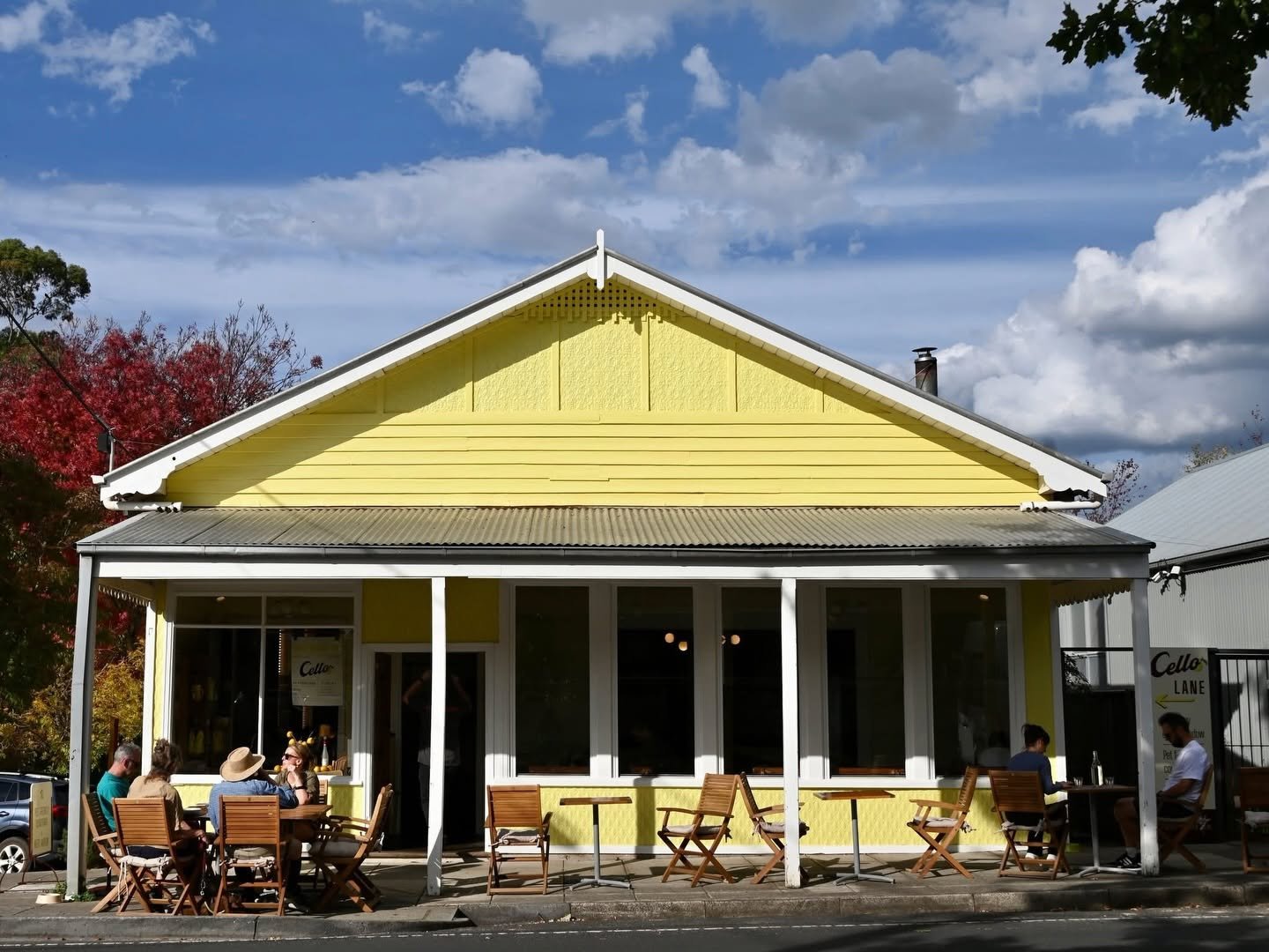A cheery yellow building in Hepburn, the old Red Star and Blue Bean Cafe. It once was Harry's too. Now Cello, home to a cosy cafe. Customers dine in the sunshine under the verandah