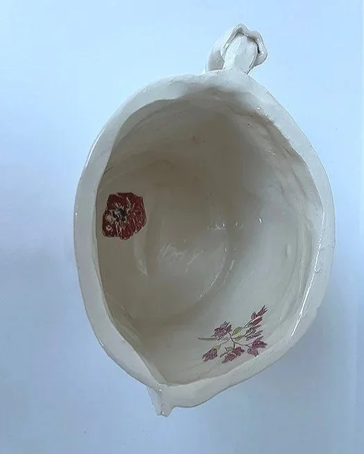 Empty ceramic bowl with a red floral design and a purple floral design inside.