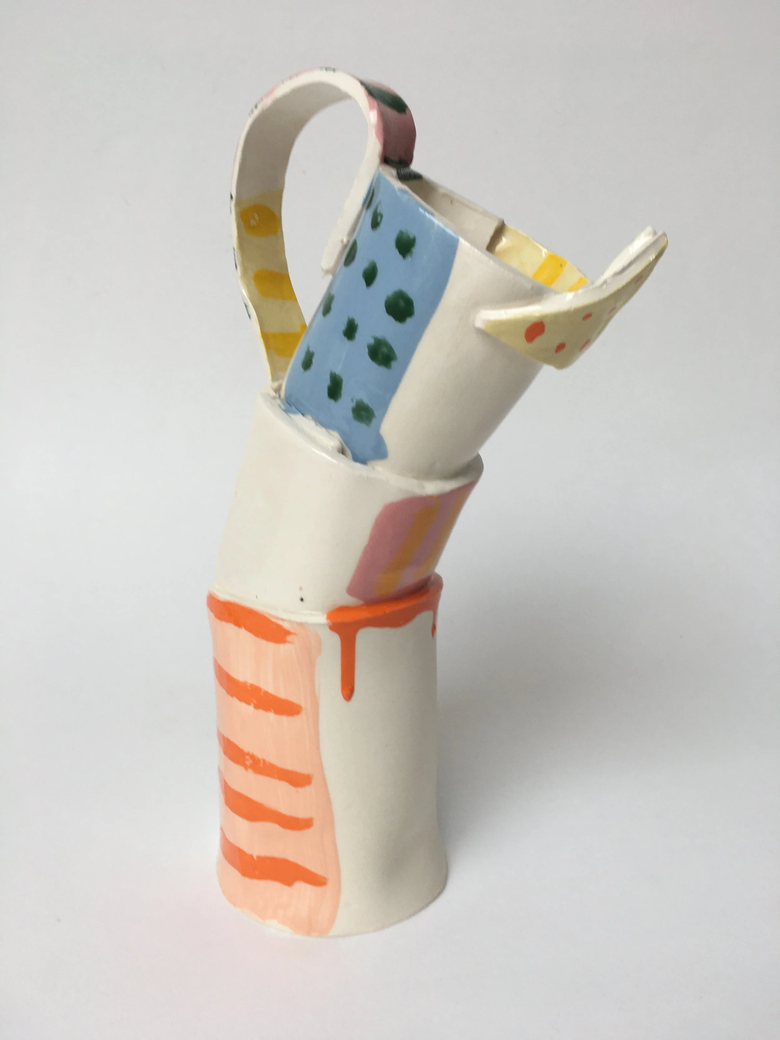 A painted hand holding a painted teacup, decorated with polka dots and pastel colors.