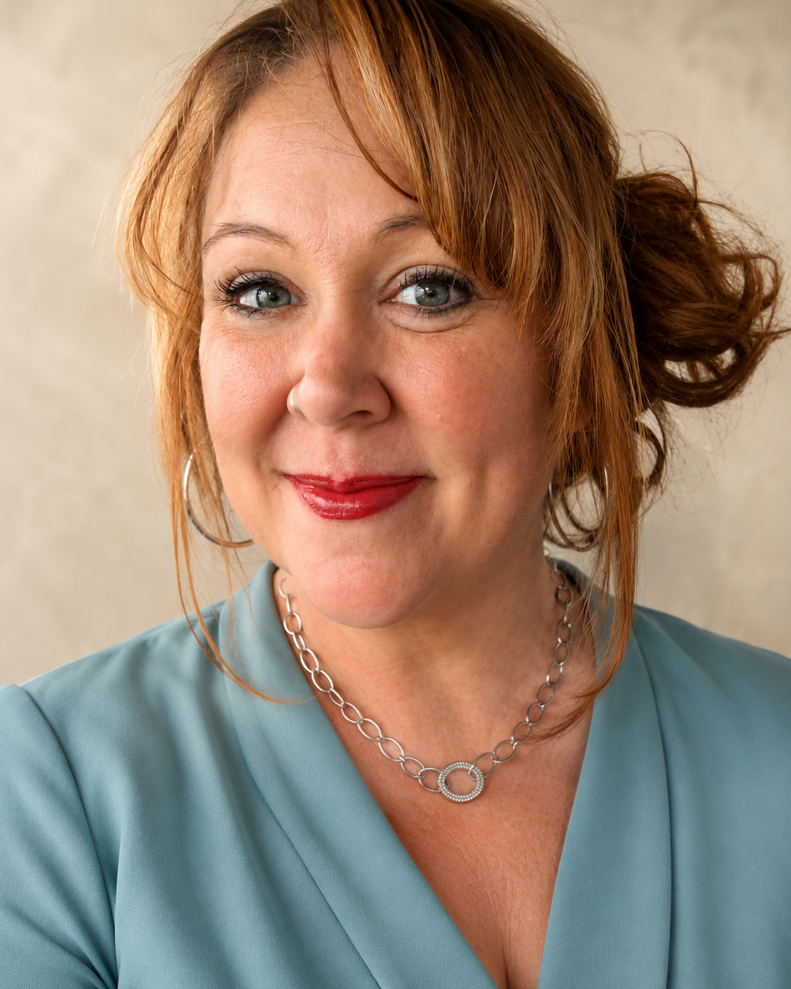 Summer Killebrew smiling in a blue blouse against a neutral background.