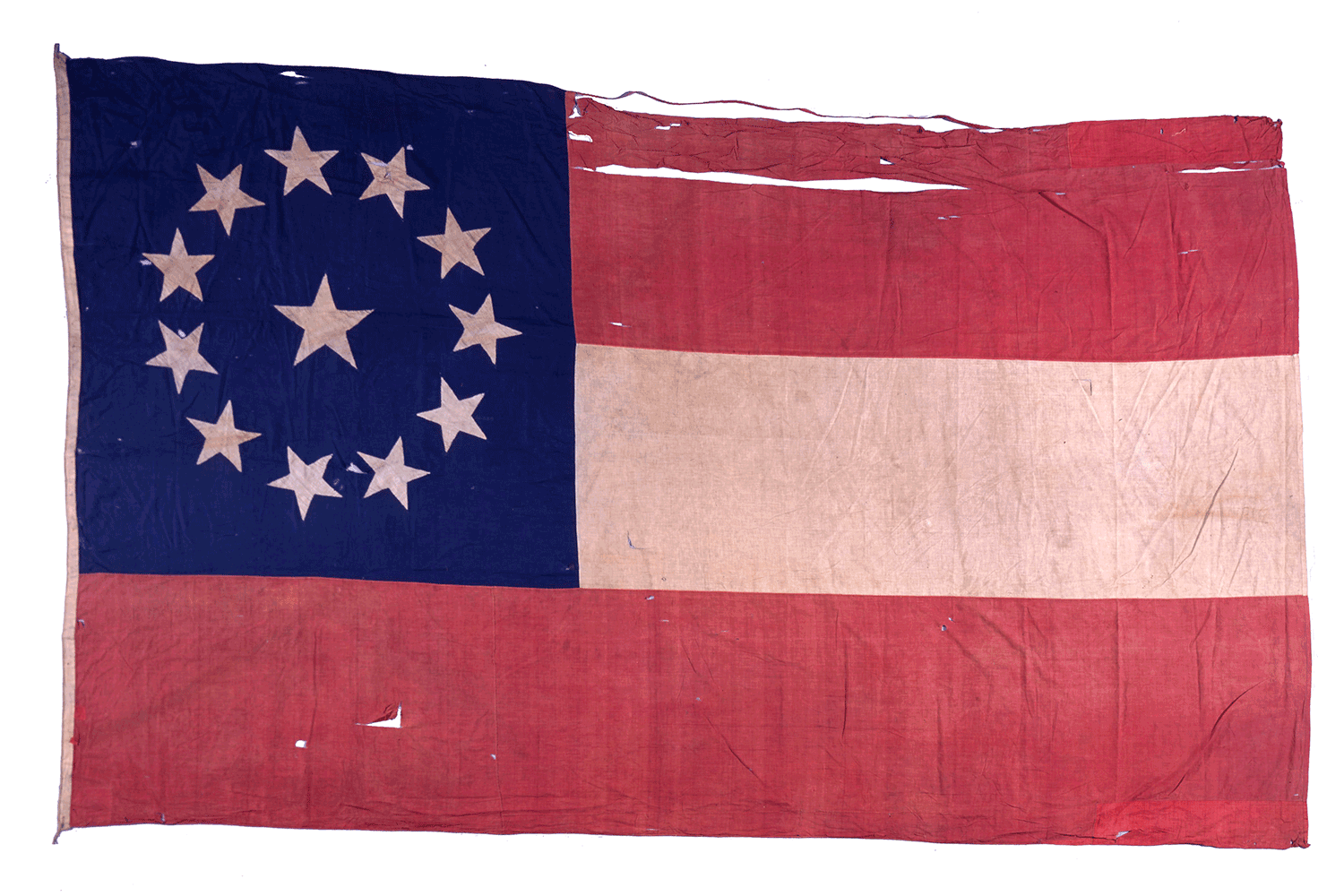 An old, tattered American flag with a blue field of white stars in a circle, red and white stripes, showing signs of wear and tear.