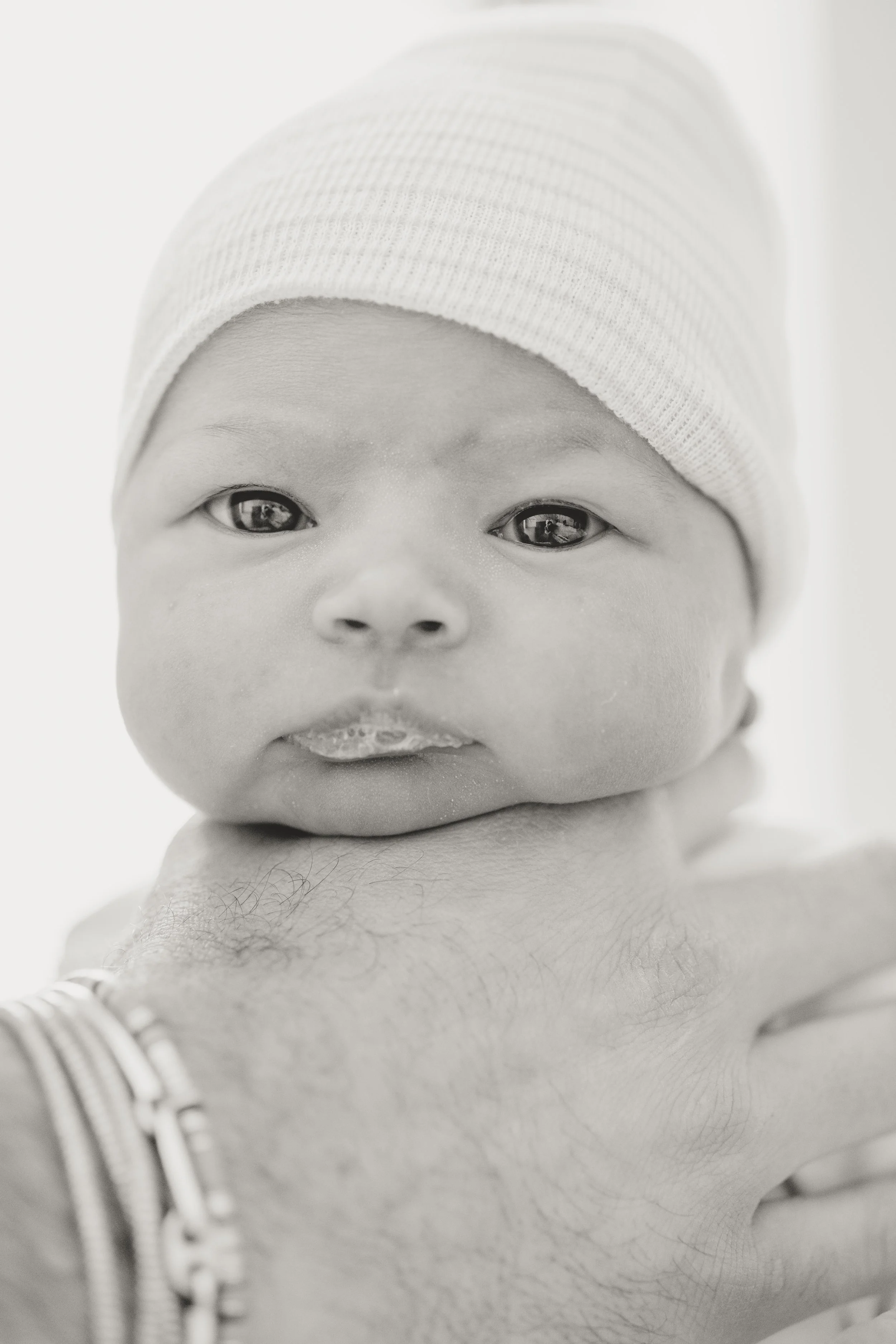 black and white hospital photos of a baby during an Austin fresh 48 photography session