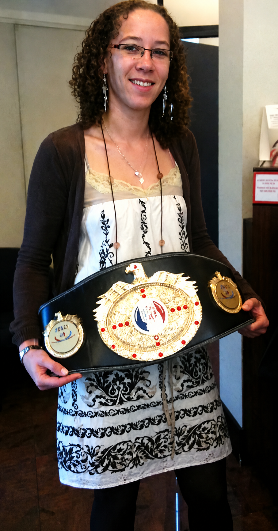 Johanna Sebille avec l'une de ses ceintures de championne de France Élite de kick-boxing, fondatrice du Muscle Au Natur'Elles et coach spécialisée dans l'accompagnement des femmes.