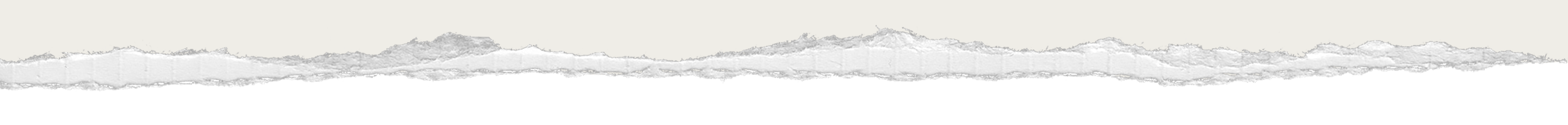 A panoramic view of mountain peaks under a cloudy sky, seen from a distance with a flat foreground.