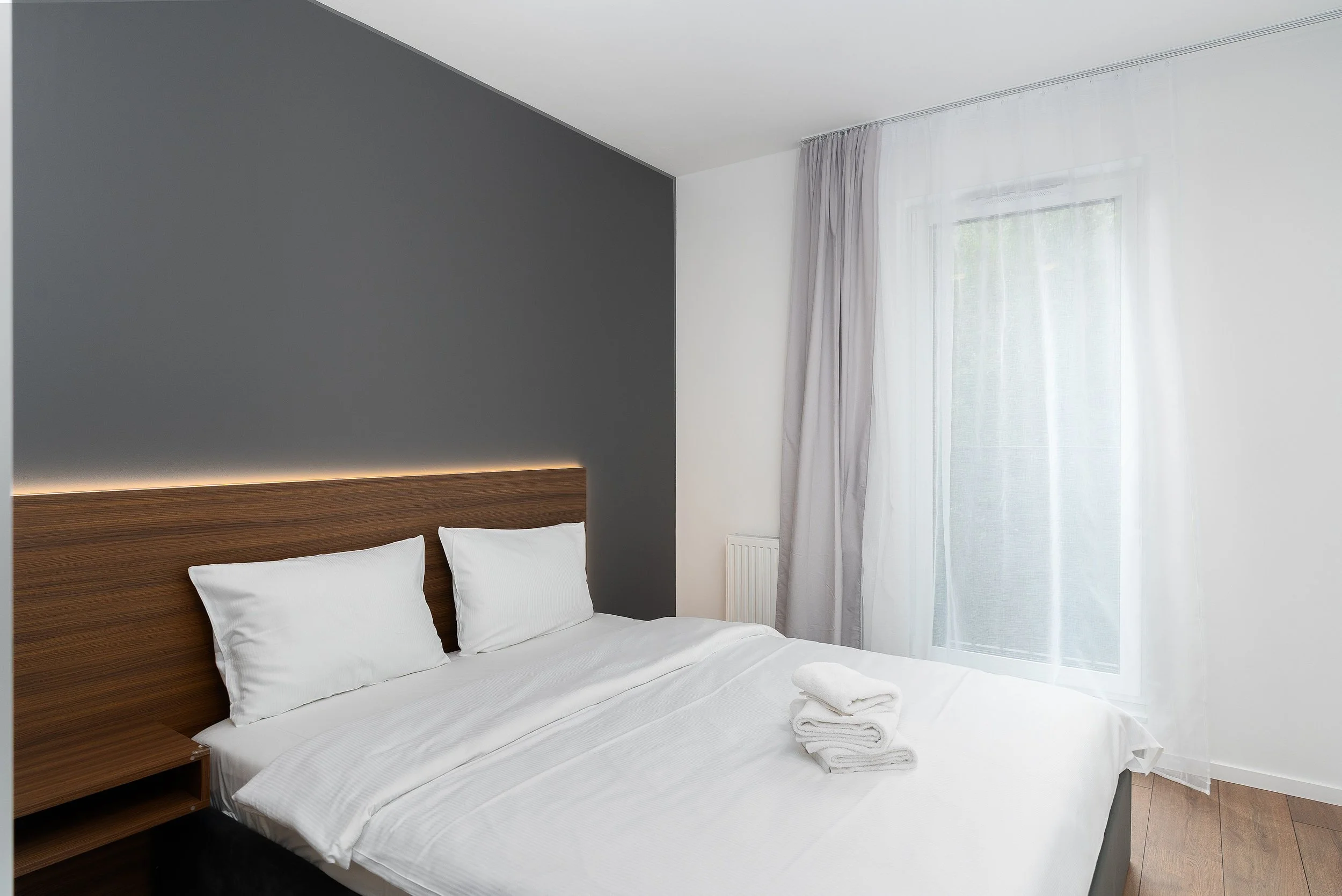 Small 1-star hotel room with a single bed, plain white linens, and a bedside table