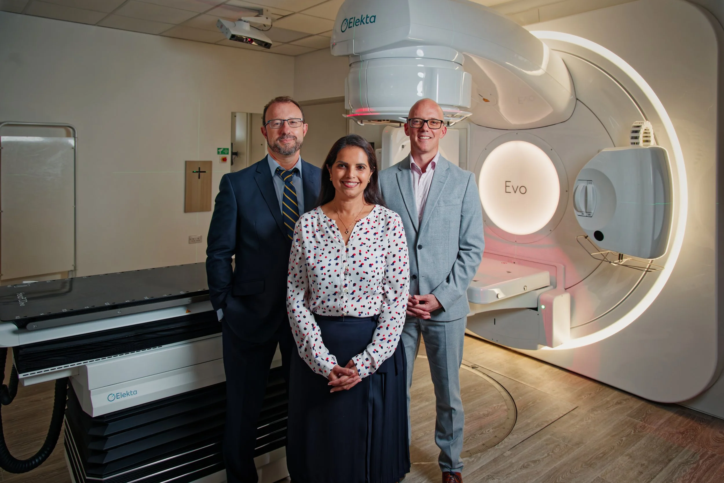 Three doctors with a MRI scanner behind them
