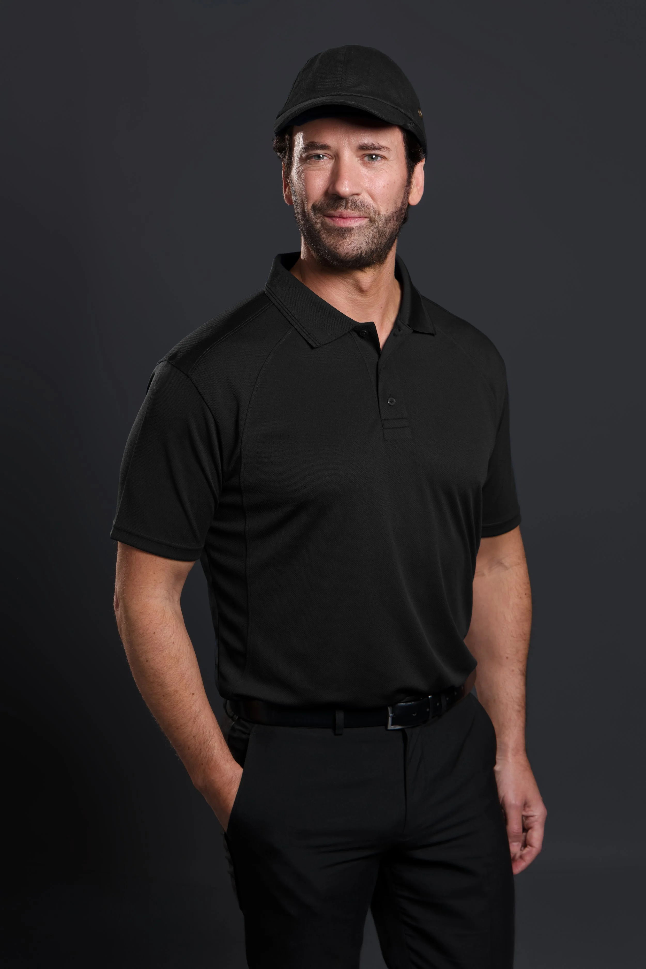 Headshot of a man wearing a cap and a polo shirt