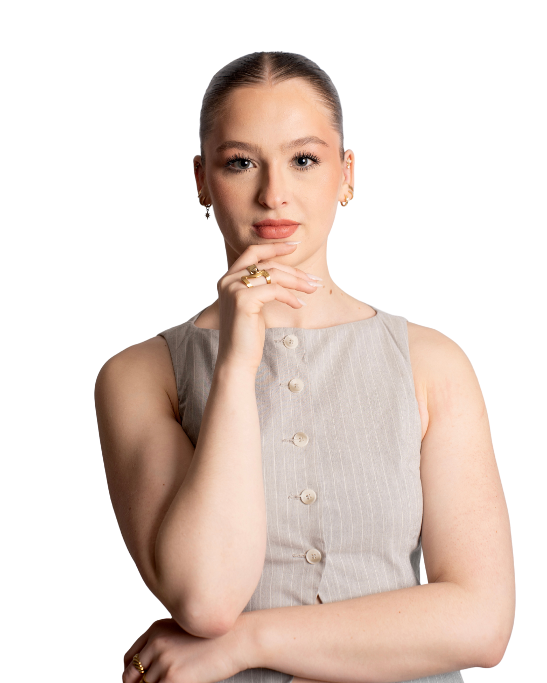 Jeune femme aux cheveux retenus, portant une robe beige à boutons, posant avec la main sous le menton, regard direct.