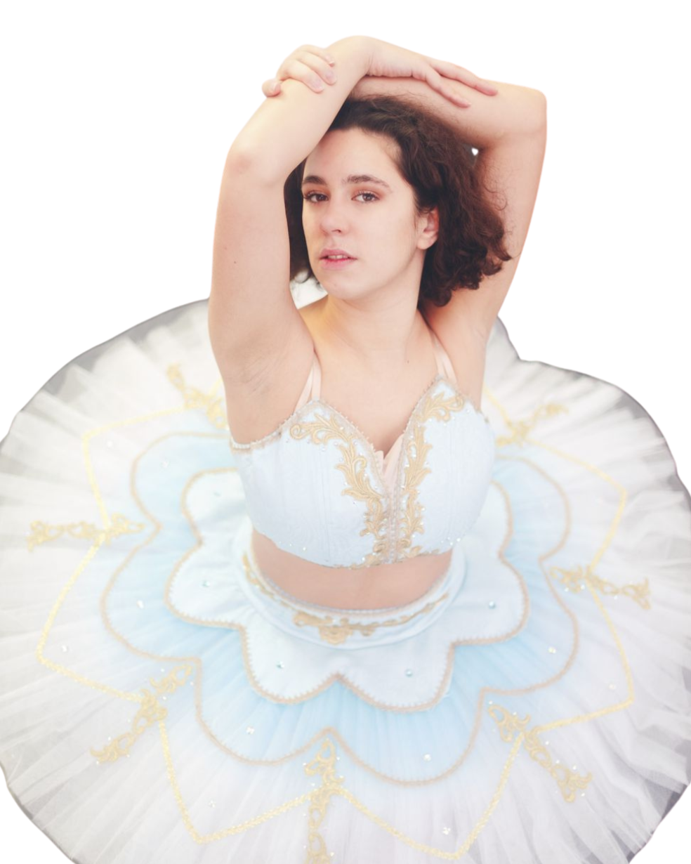 Femme portant un tutu blanc avec des détails dorés, levant les bras au-dessus de la tête, avec une expression neutre, fond blanc.
