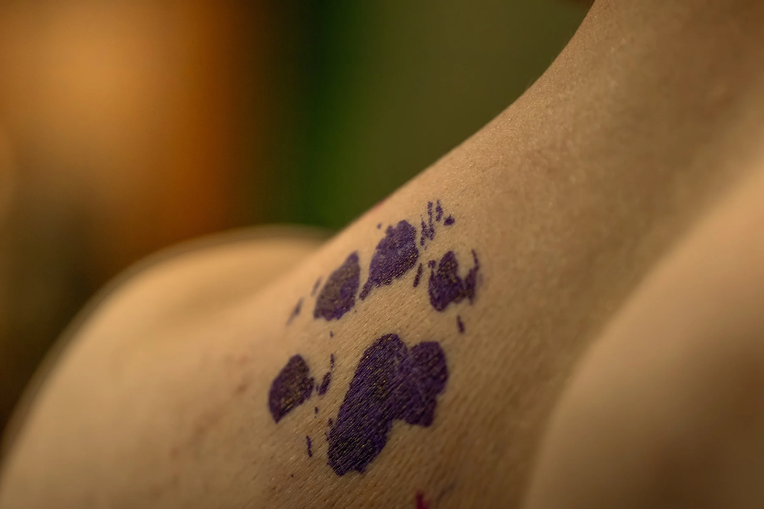 Close-up of a brown paper surface with purple ink stamped letters, slightly blurred at the edges.