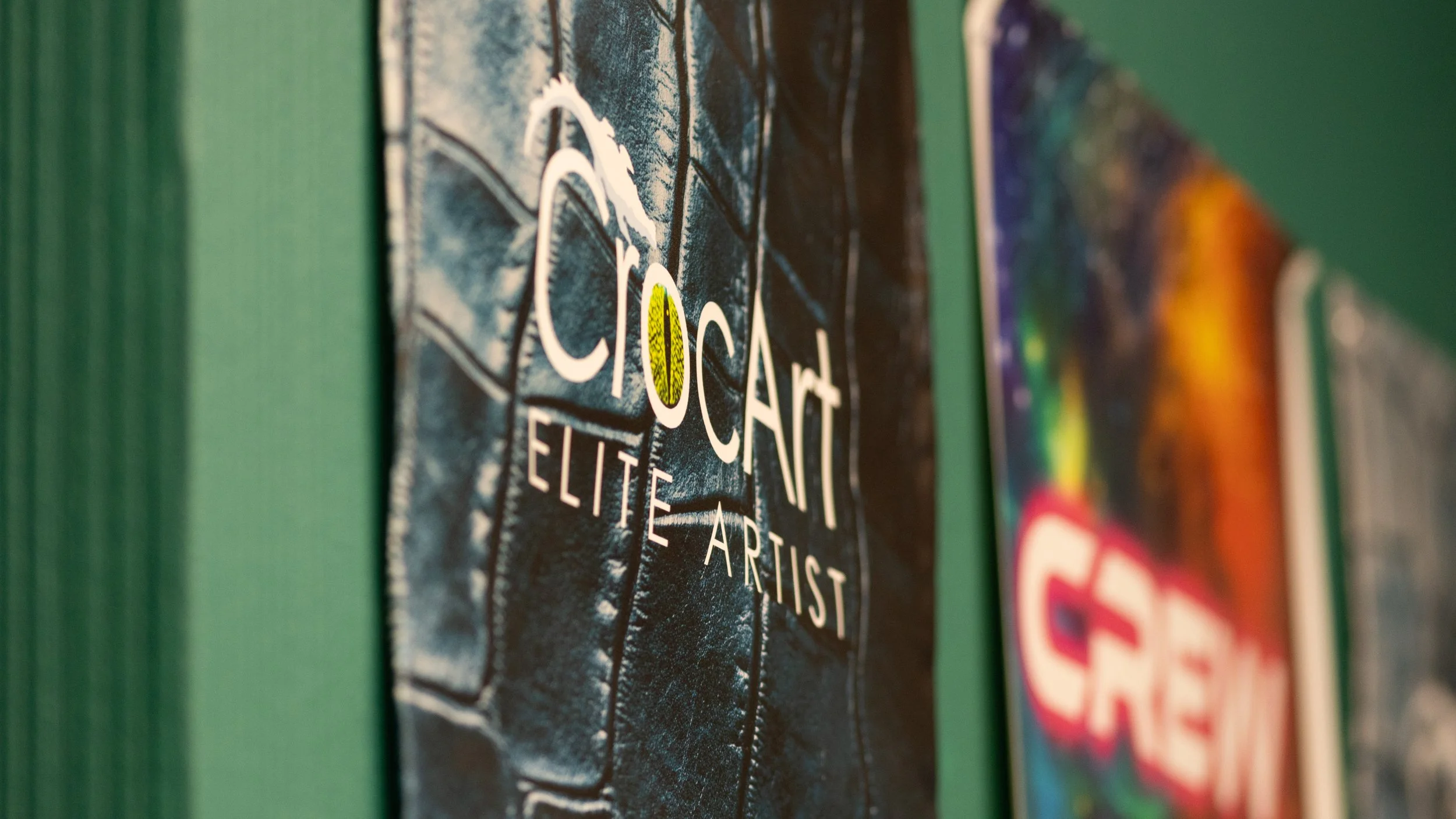 Close-up of a poster or artwork with the words "Coaching Elite Artist" and a stylized depiction of a guitar.