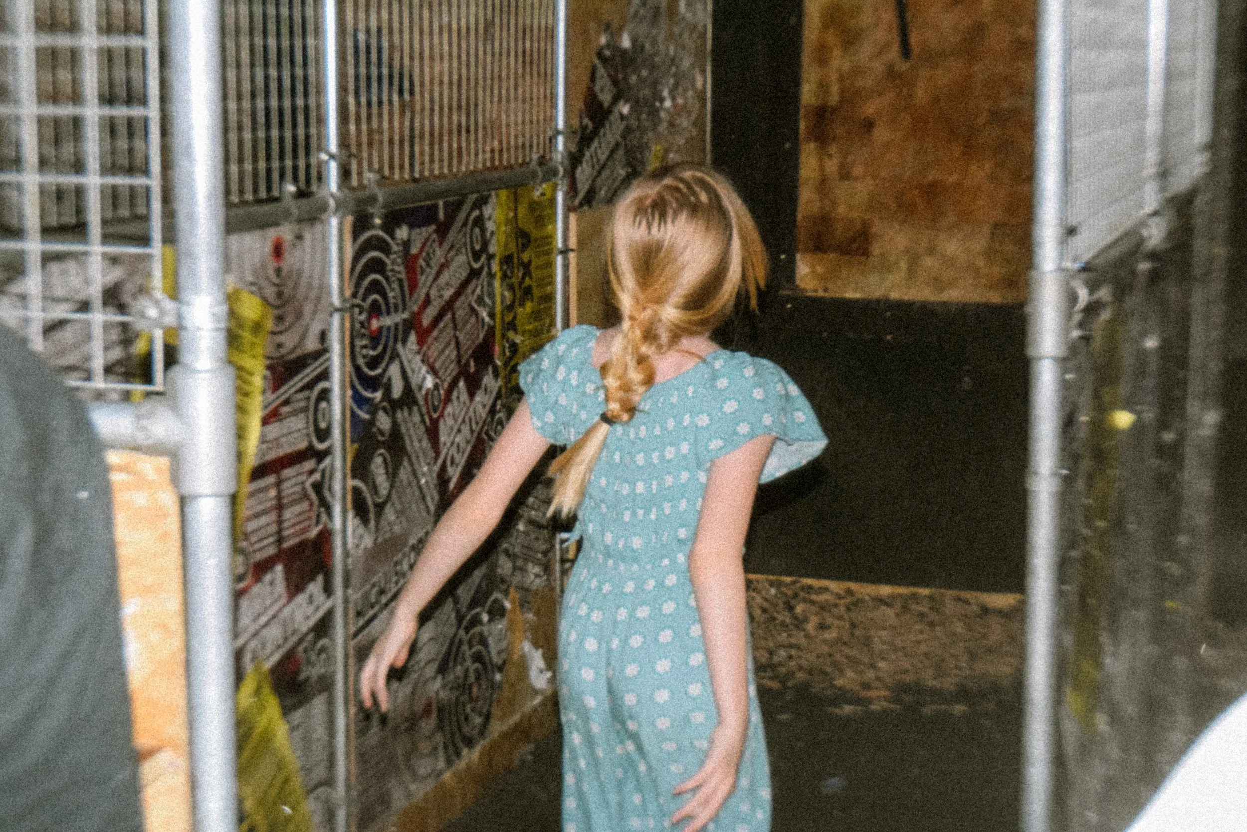 young kid participating in ace throwing with her back to the camera