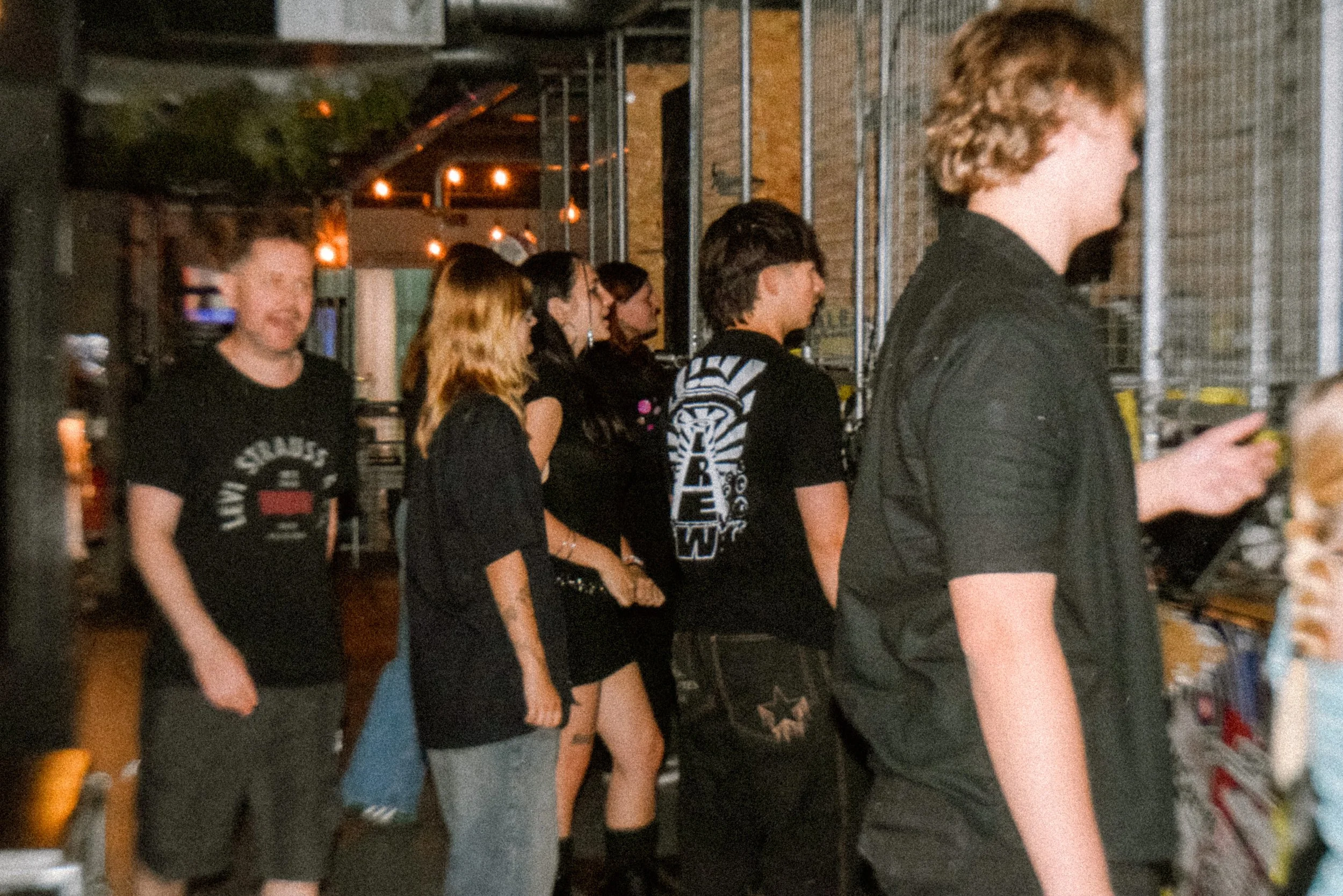 A busy axe throwing venue with lots of people stood in line to throw axes