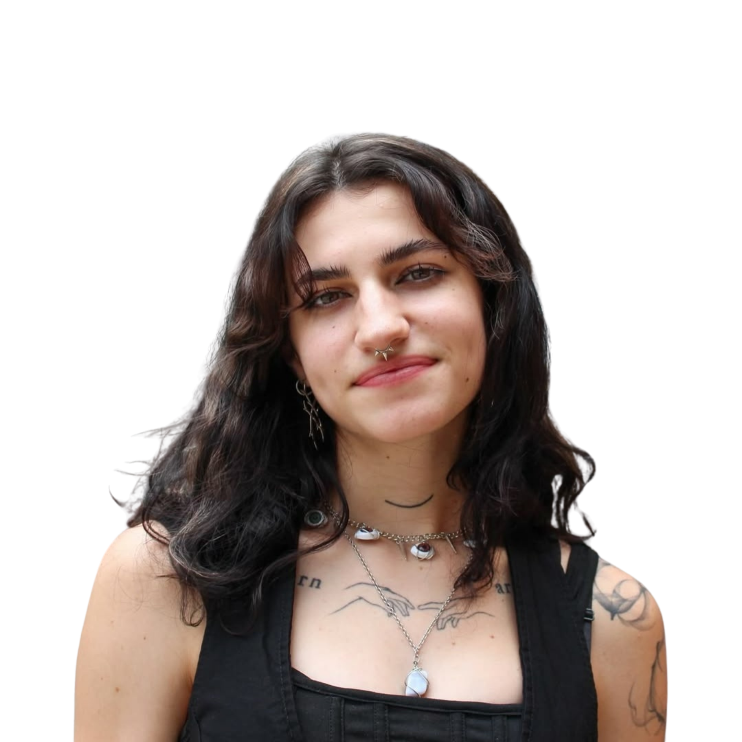 Close-up of a woman with dark wavy hair, tattoos on her chest, wearing jewelry, and a nose ring, smiling slightly.