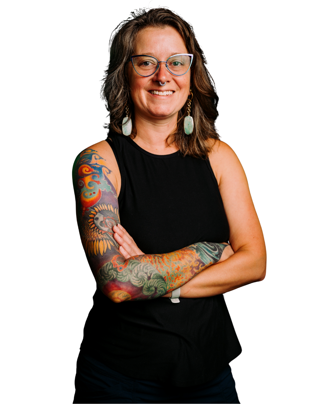 Portrait of a woman with tattoos on her arm, wearing glasses, earrings, a black sleeveless top, and smiling.