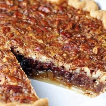 A close-up of a slice of cherry and crumb cake on a white plate, showing the crumb topping and cherry filling.