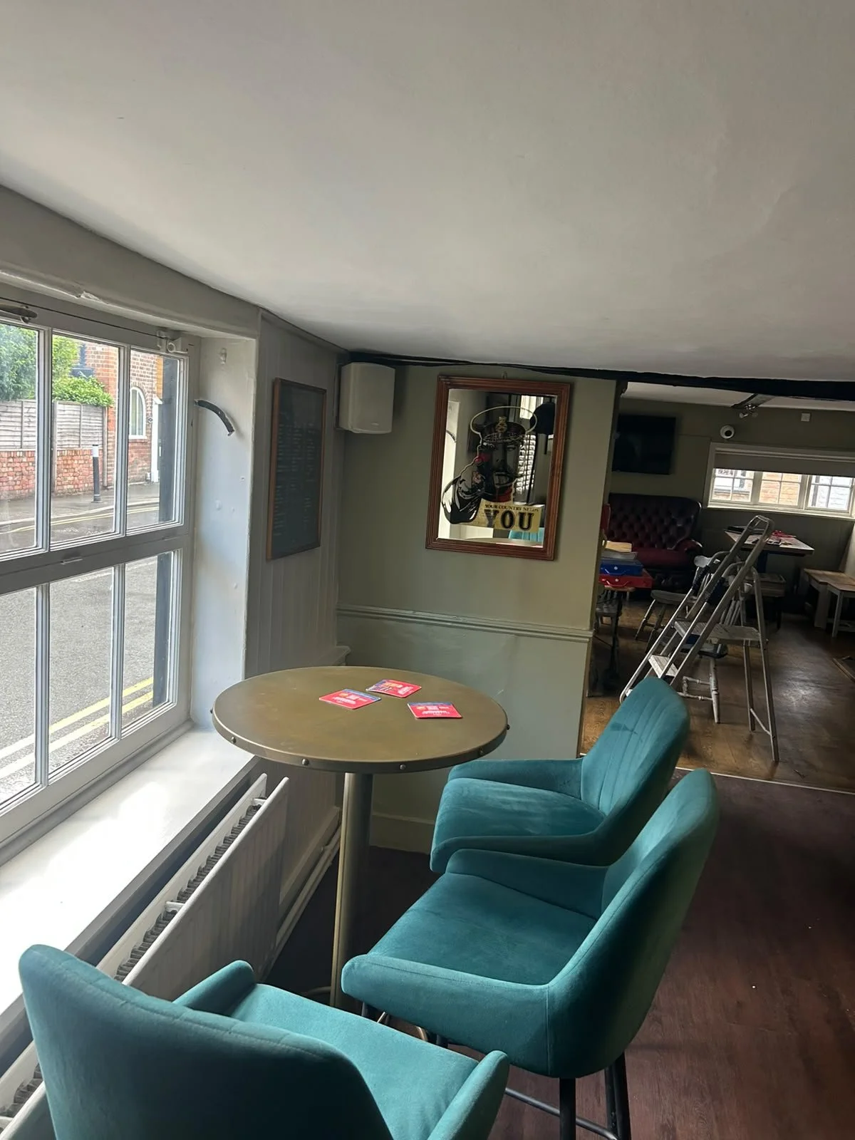 Interior of the beautifully refreshed Coachmakers Arms in Wallingford. Teal upholstered bar chairs look out on to St Mary Street from you favourite local.