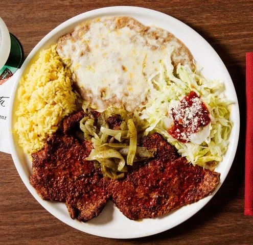 A plate of fried chicken, yellow rice, mashed potatoes with gravy, and a side salad with lettuce and marinara sauce.