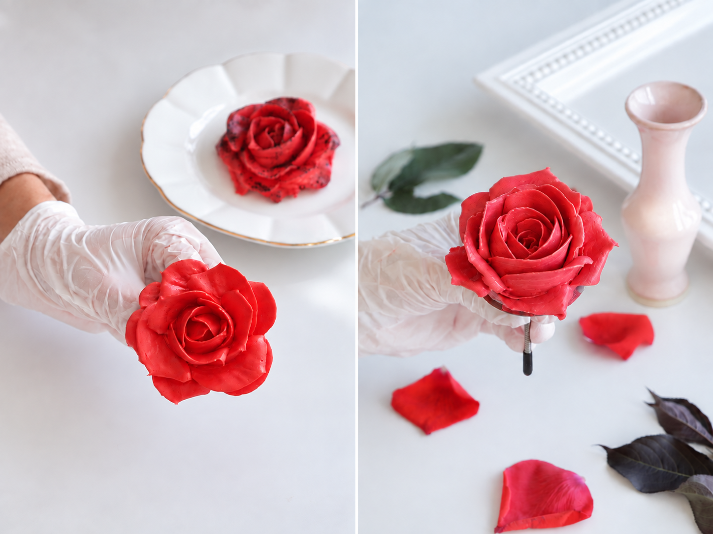 A white surface with a gloved hand holding a pink rose, red rose petals, and dark green and purple leaves, next to a pink ceramic vase and a white decorative frame.