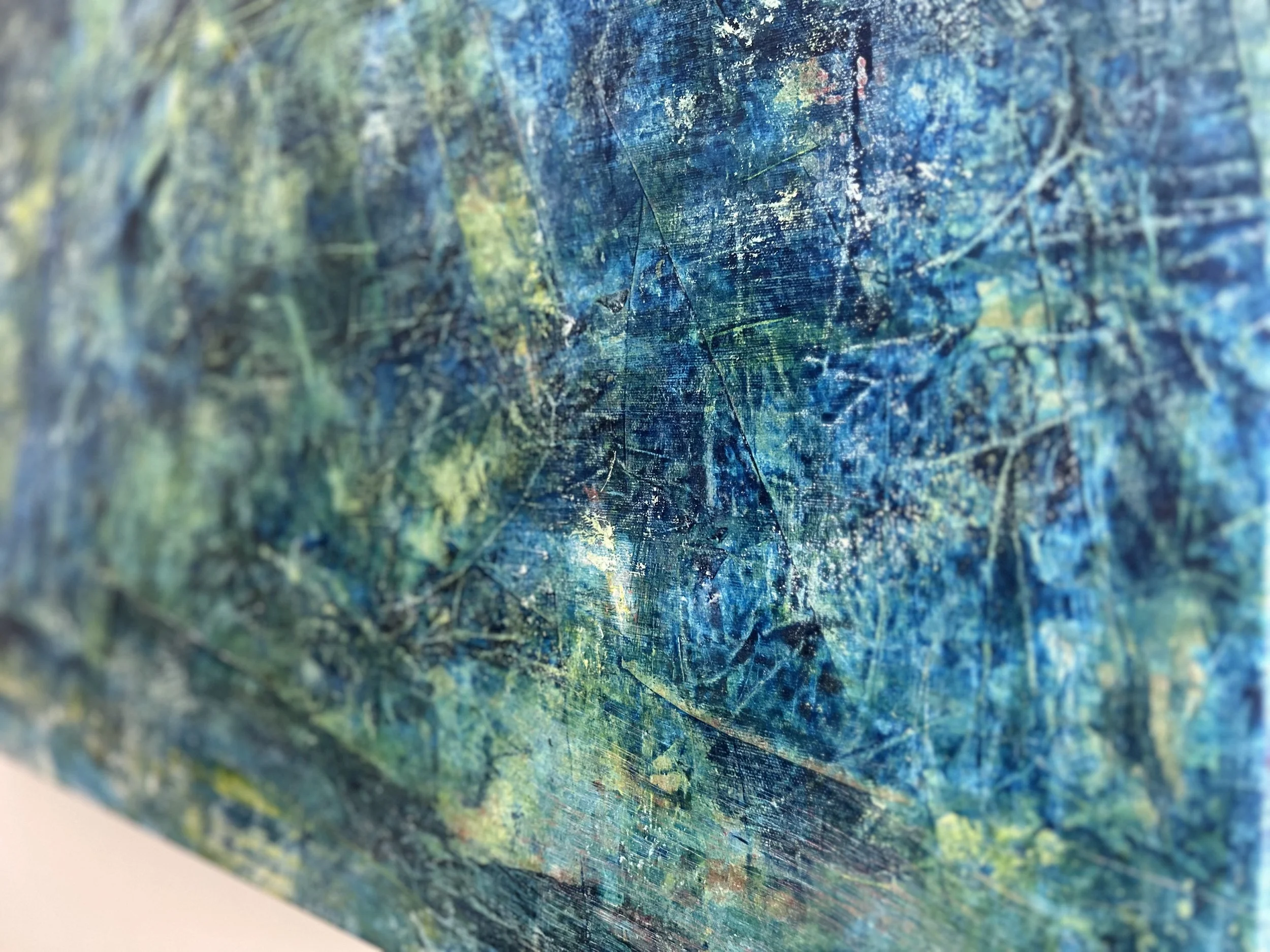 Close-up view of a textured, abstract painting with blue, green, and yellow hues and visible brushstrokes.