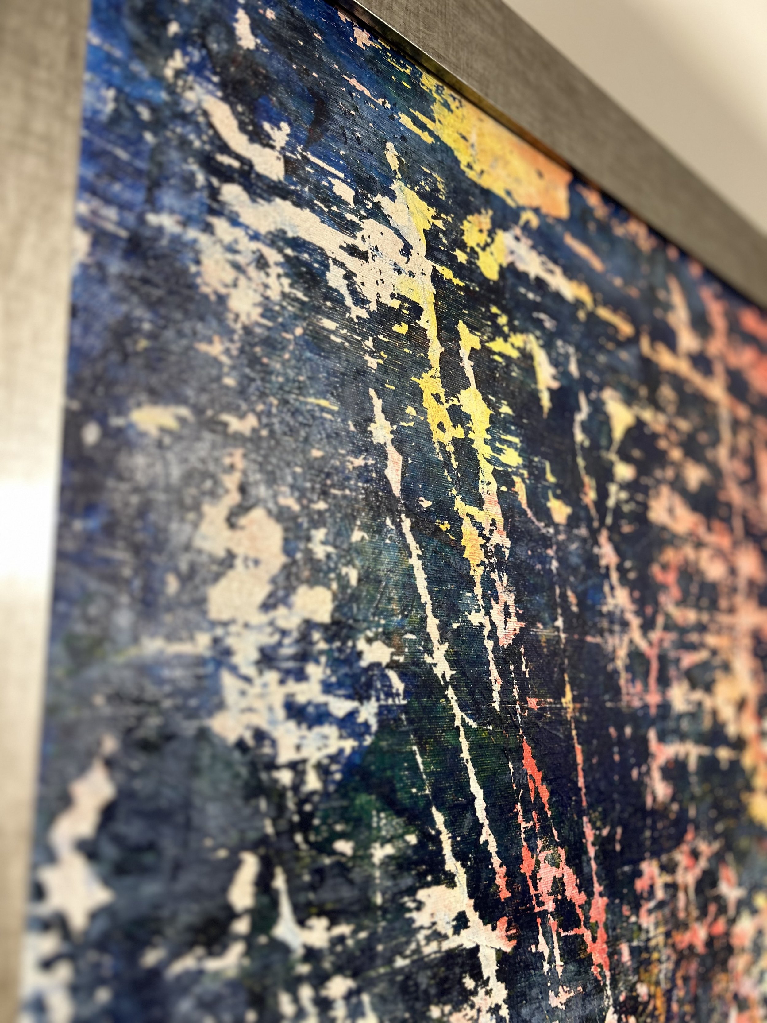 Close-up of an abstract textured painting with splashes of white, yellow, orange, pink, and blue on a dark background.