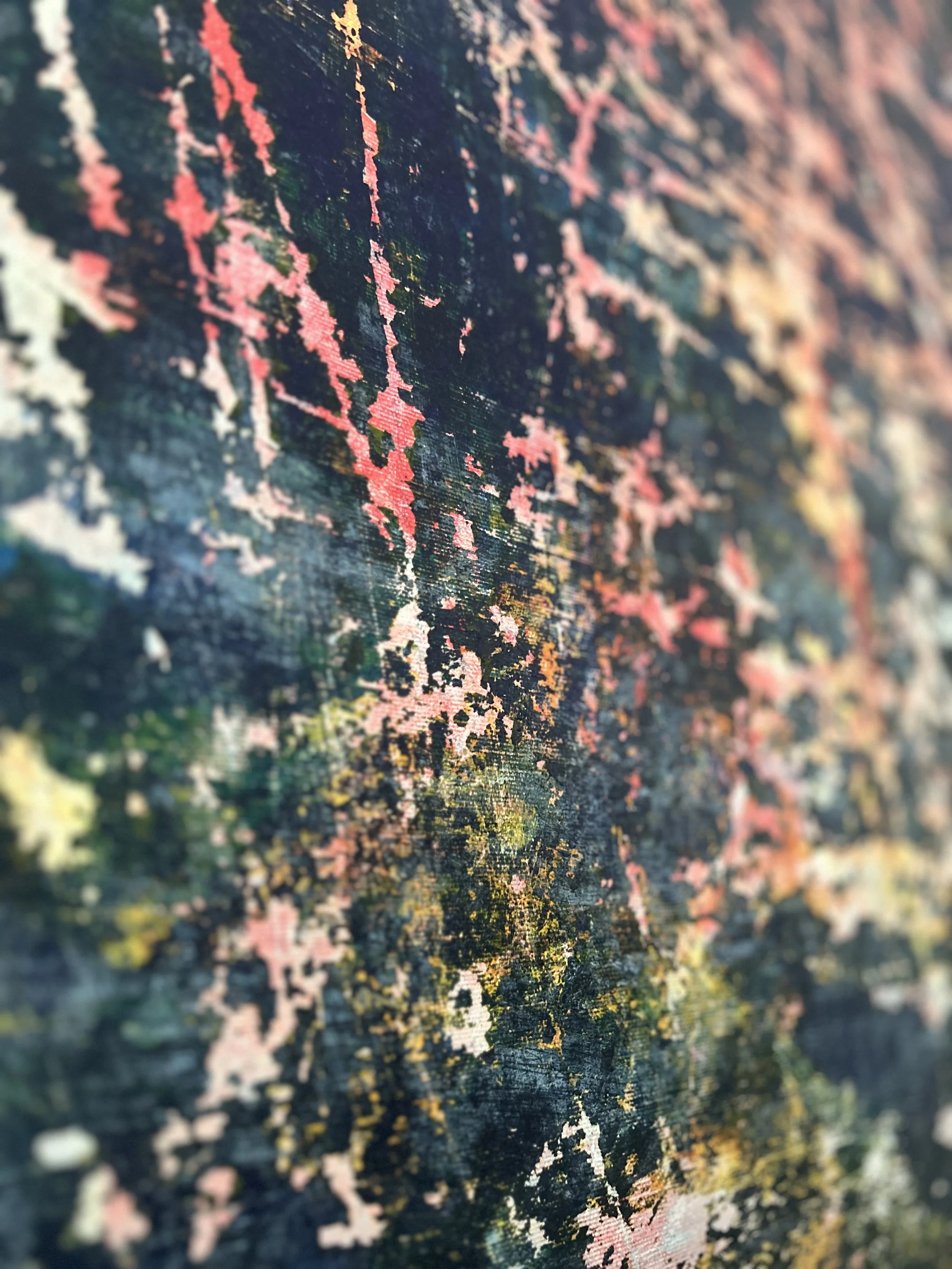 Close-up of a textured surface with colorful floral or abstract patterns in pink, yellow, and green on a dark background.