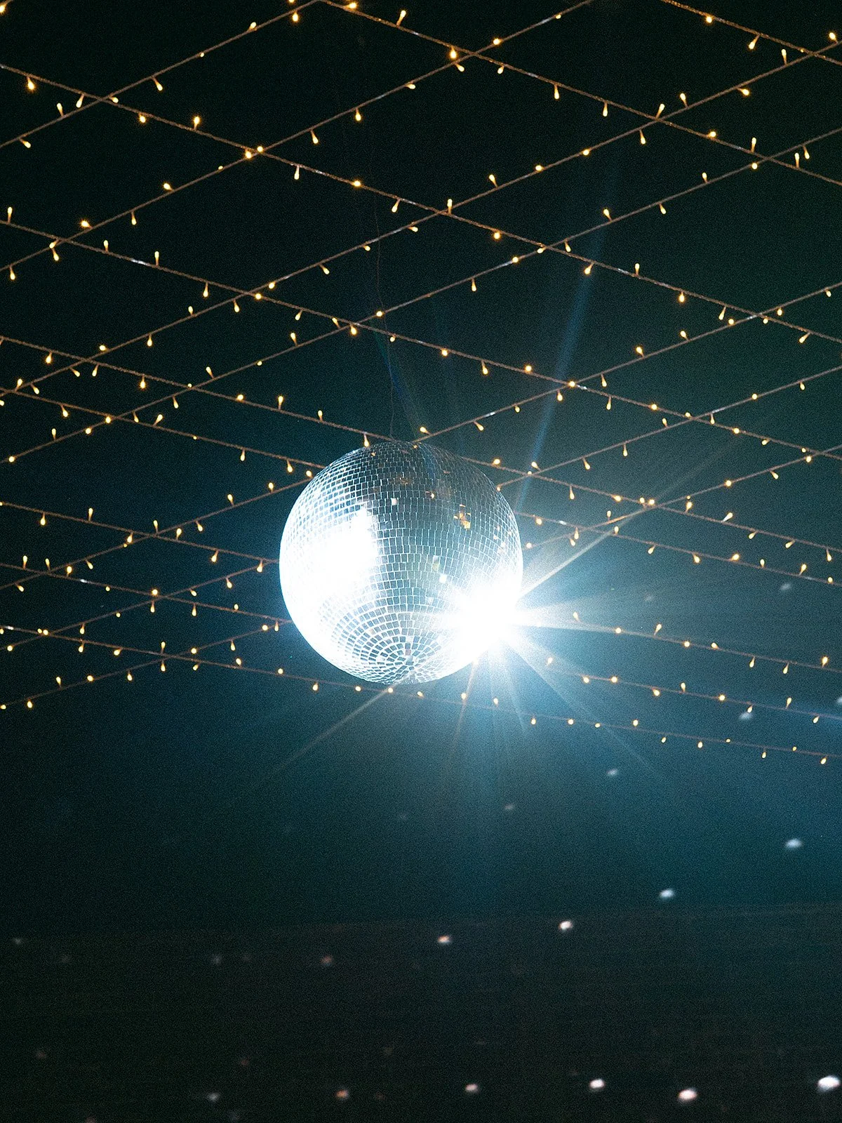 Espejo de bola y luces decorativas en el techo en un ambiente de fiesta nocturno.