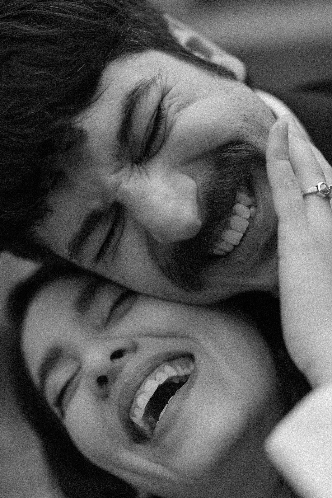 Dos personas riendo y divirtiéndose, una con ojos cerrados y la otra con sonrisa abierta mostrando dientes.