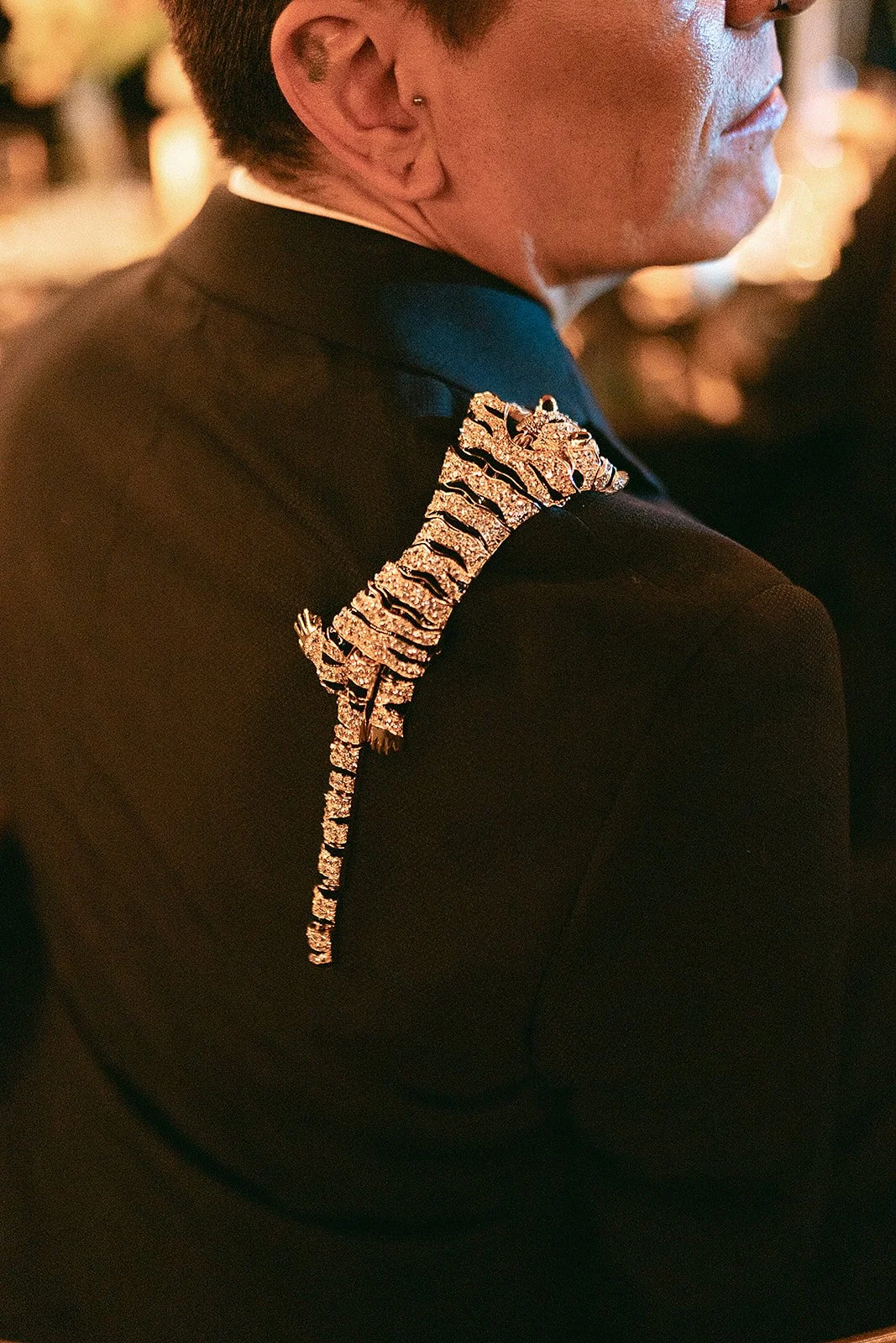Hombre con un pin del tigre de diamantes en su chaqueta tuxedo en un evento formal