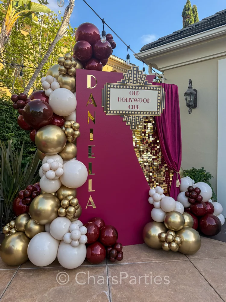 Burgundy, gold and white balloon installation with Hollywood-style backdrop
