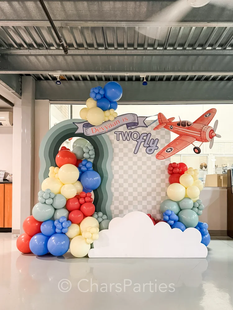 Red, blue and cream balloon garland with airplane backdrop