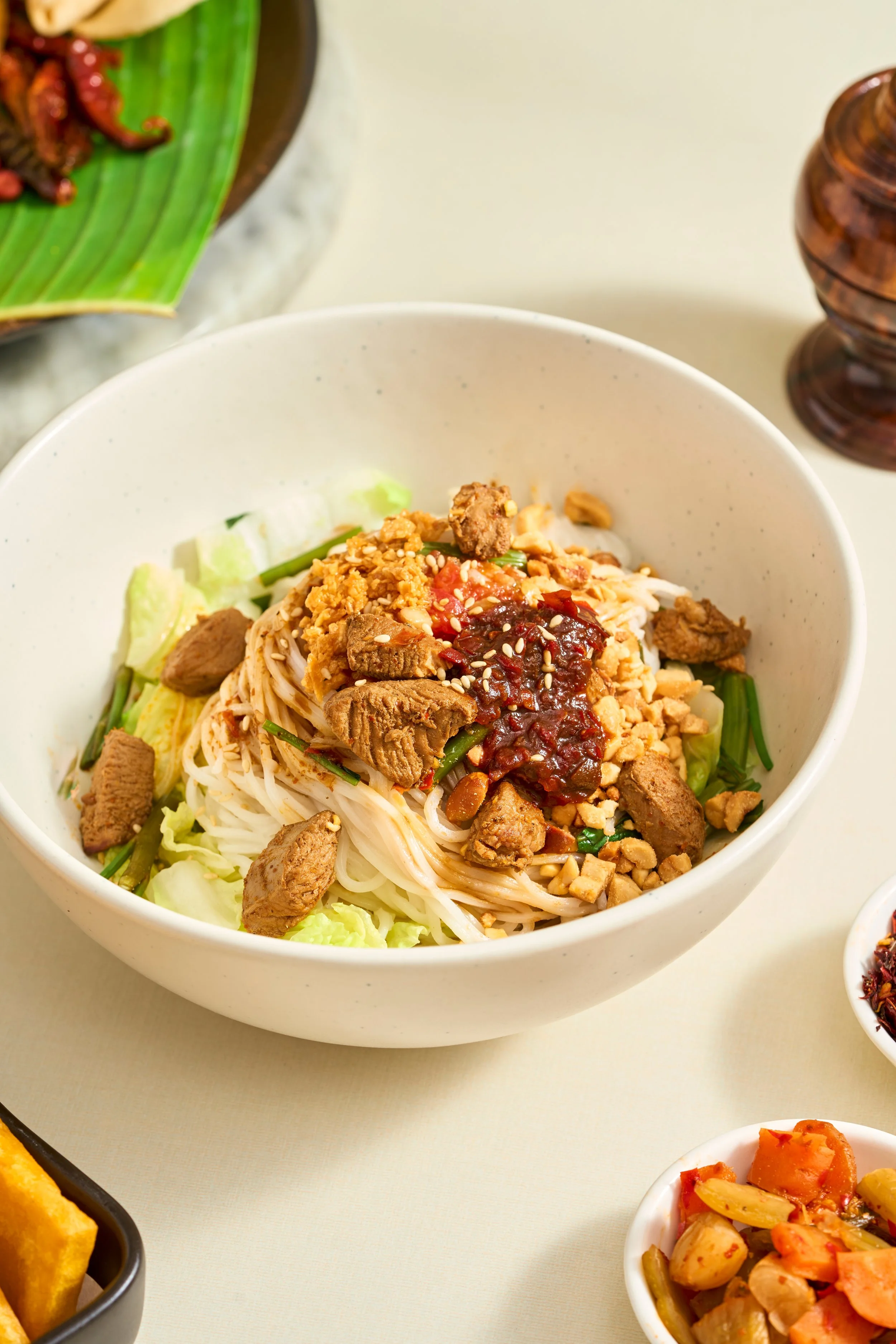 SHAN KHAO SWE (Shan State Sticky Noodles)

The defining culinary export of the Shan highlands, carrying a cross-generational comfort legacy. Chewy, flat sticky rice noodles are topped with a deeply savory minced chicken and tomato stew, enriched with