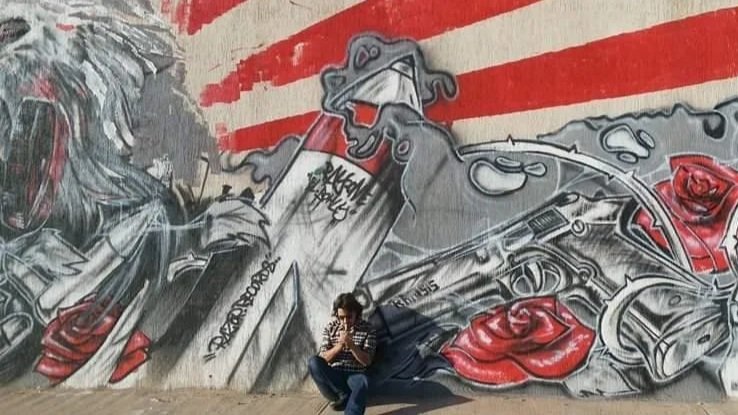 Kris next to a millitary themed mural in Tripoli, Libya during Arab Spring circa 2012/13