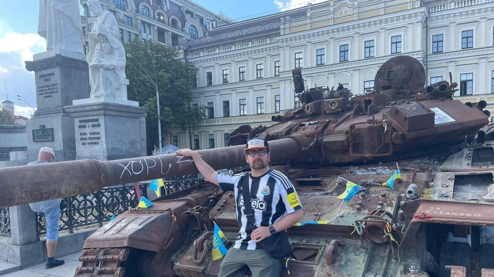 Kris Tate in Kyiv next to destroyed Russian tank.