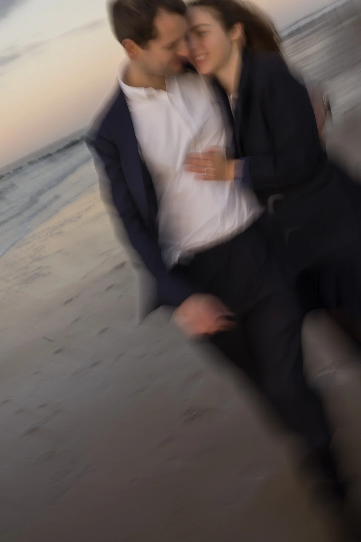A blurry photo of a man and woman smiling and touching. Beach Knokke-Heist, België. Engagement