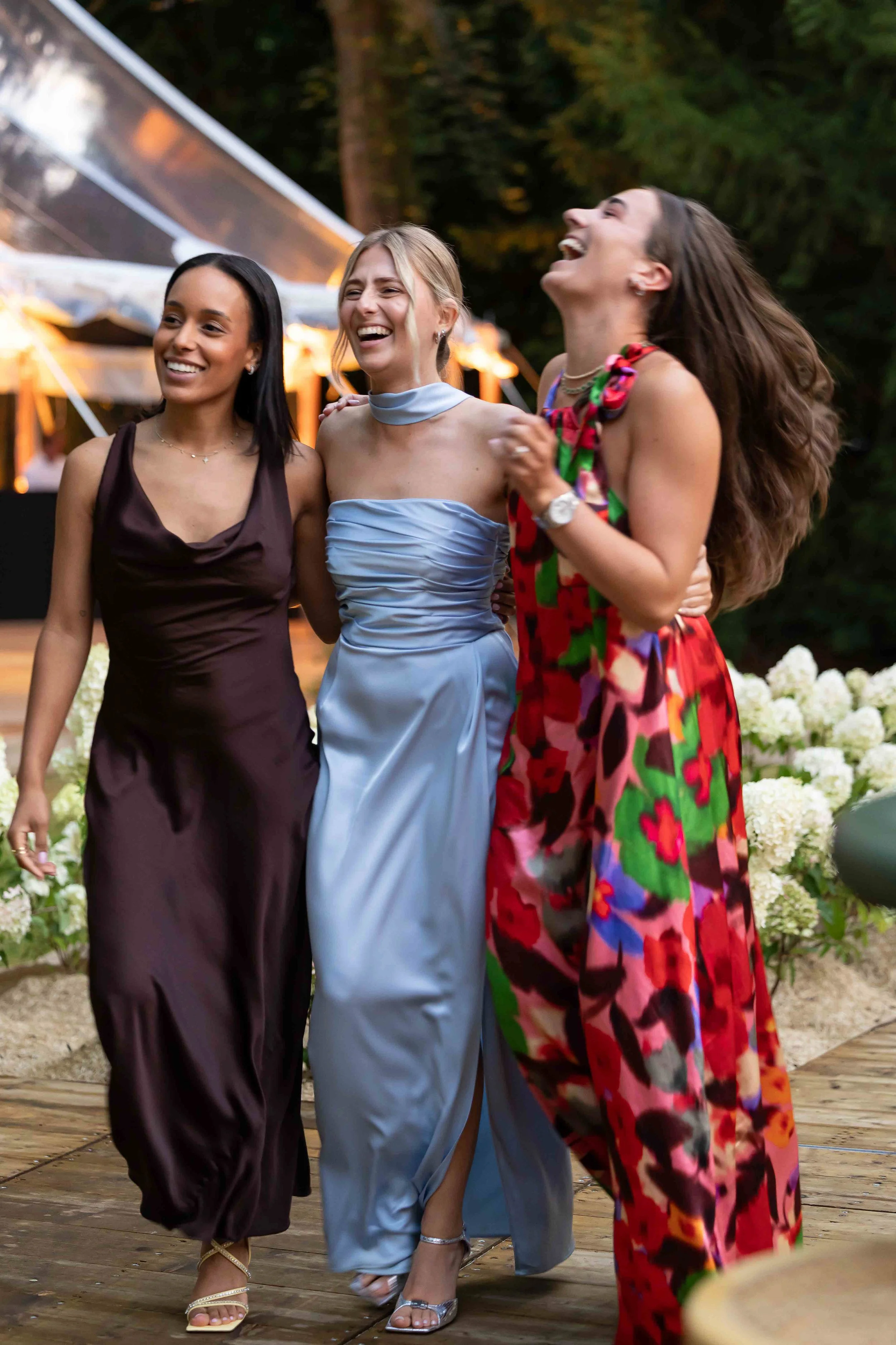 Best friends laughing at wedding reception on tent deck