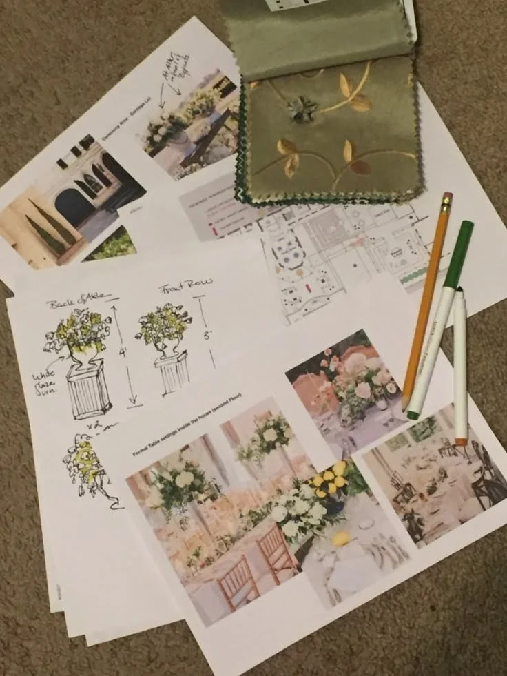 Design plans, sketches, and photos for floral arrangements and event decor, with a decorative box and pens on the documents.