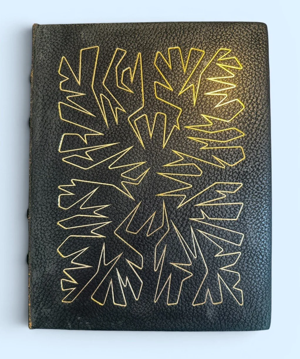 Black textured notebook with gold geometric lightning bolt design on the cover.