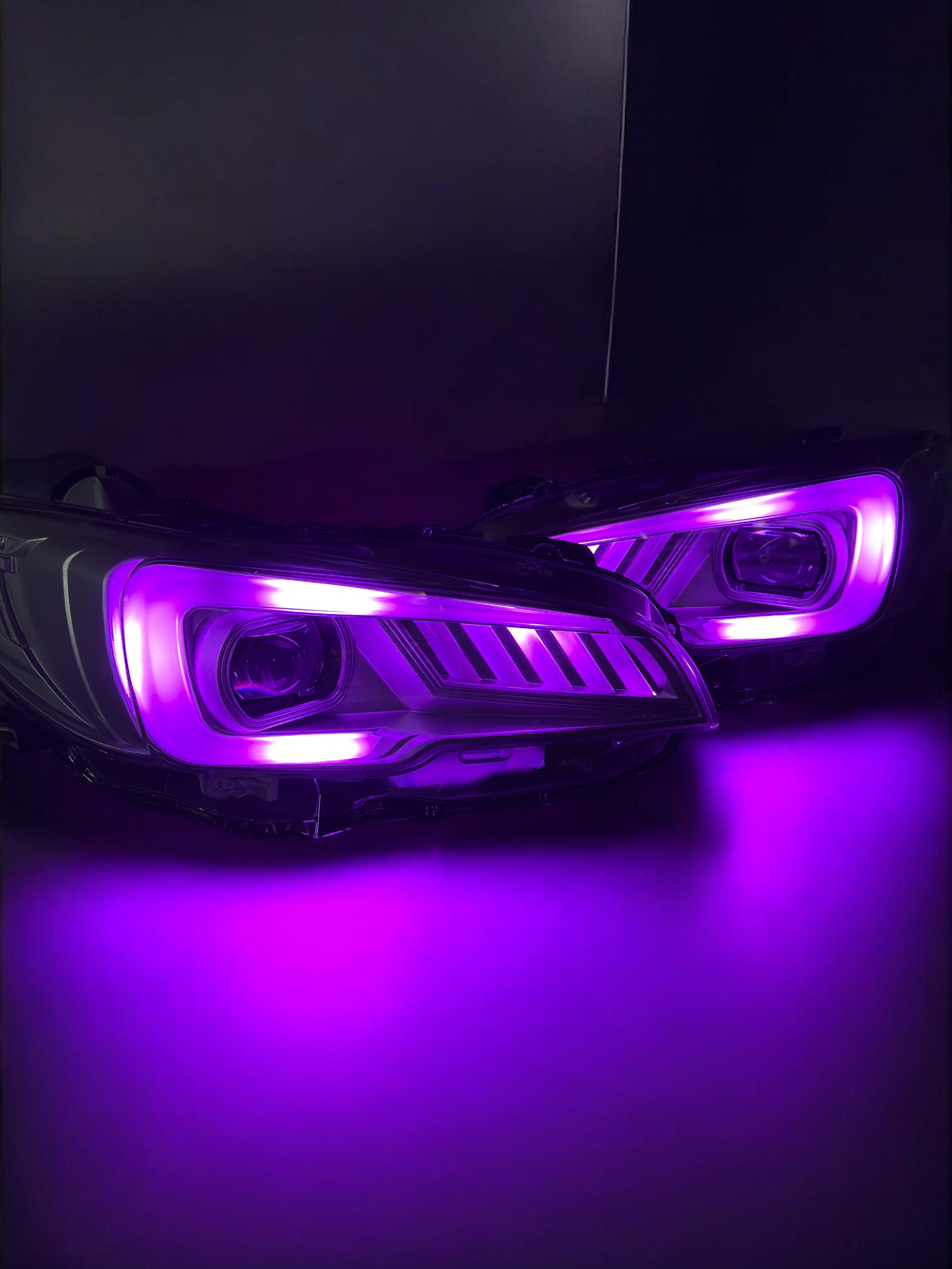 Close-up of car headlights with purple LED lighting.