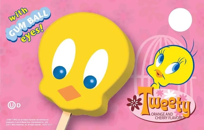 A yellow Tweety Bird character ice pop with blue gum ball eyes on a pink background, featuring a small illustration of Tweety Bird's face and the text "with gum ball eyes!" and "Tweety orange and cherry flavor."