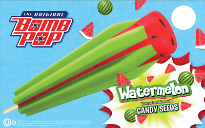 A watermelon-shaped popsicle with a red top and green body, decorated like a watermelon. The packaging features the Bomb Pop logo, watermelon slices, and the text 'Watermelon' and 'Watermelon & lime taste with candy seeds'.