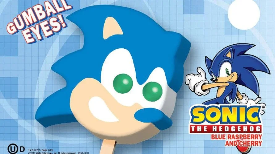 A Sonic the Hedgehog themed popsicle featuring Sonic's face with Gumball Eyes and a separate image of Sonic in a running pose. The packaging displays the Sonic logo with flavors Blue Raspberry and Cherry.