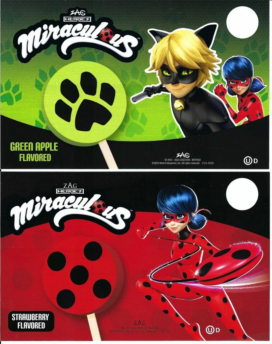 Two juice boxes featuring characters from Miraculous. The top box is green apple flavored with a character wearing a black cat costume and a ladybug symbol, and a girl with blue hair in a red and black costume. The bottom box is strawberry flavored w